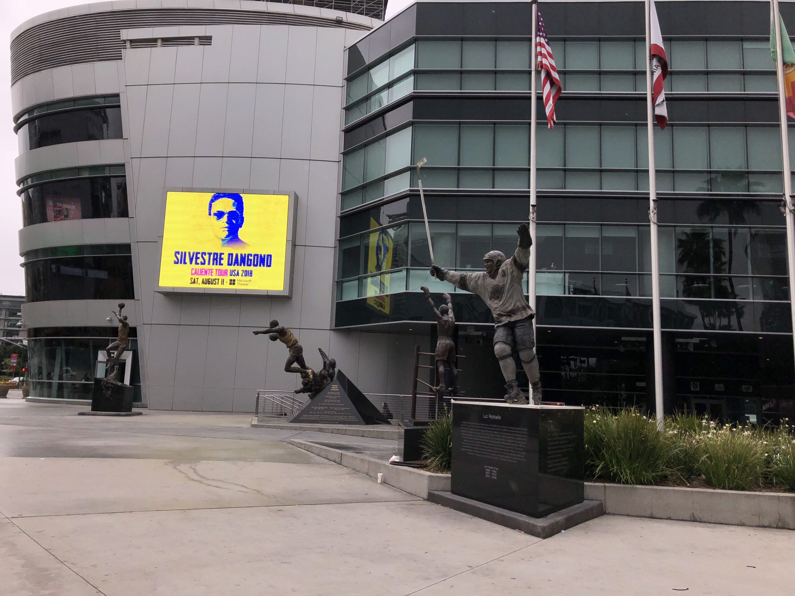 alt="statues of sports men outside building"