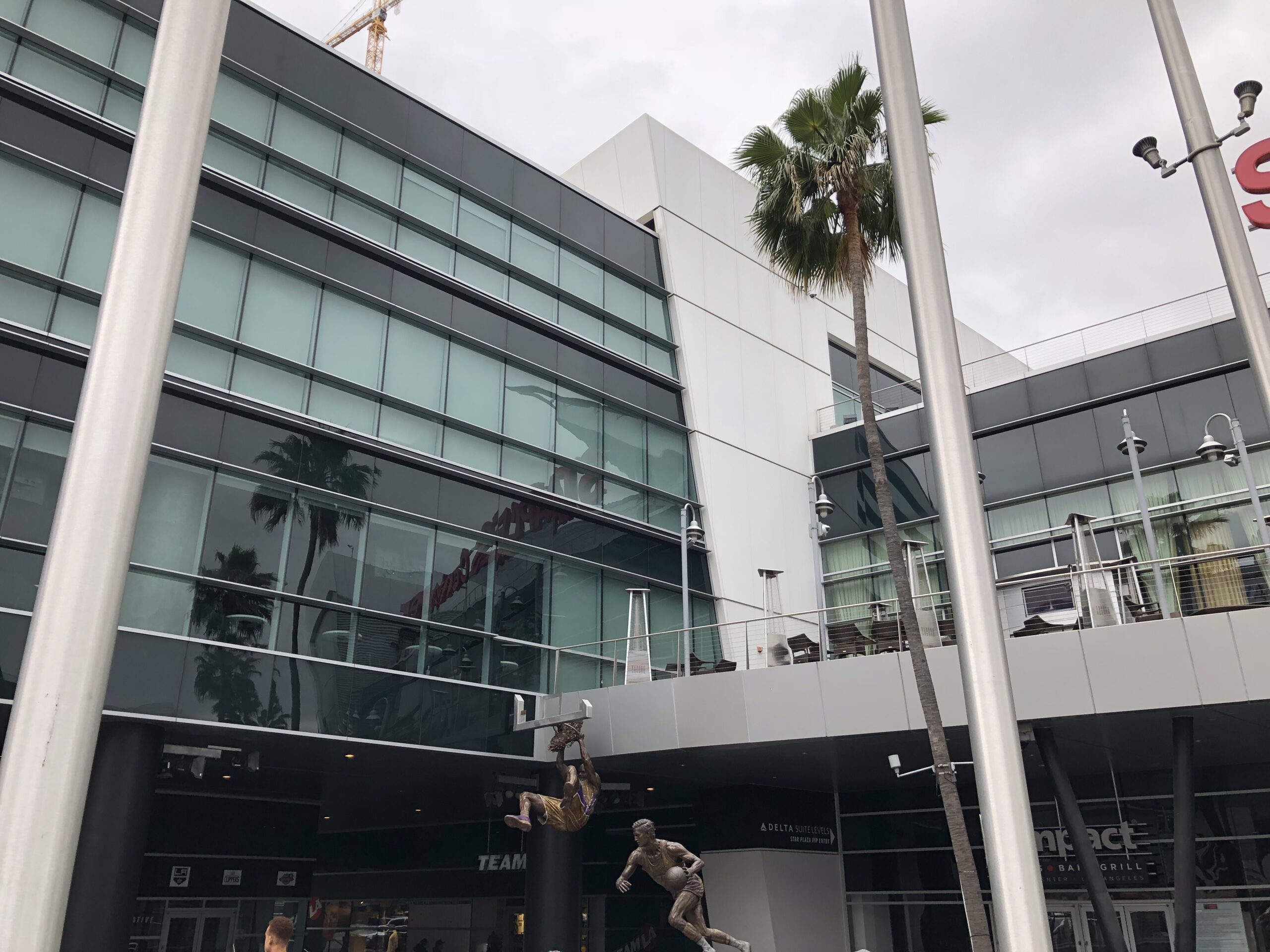 alt="statues of sports players outside stadium"