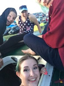 alt="people sat on roof of camper van"