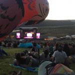 alt="sat on grass looking at main stage The Gorge"