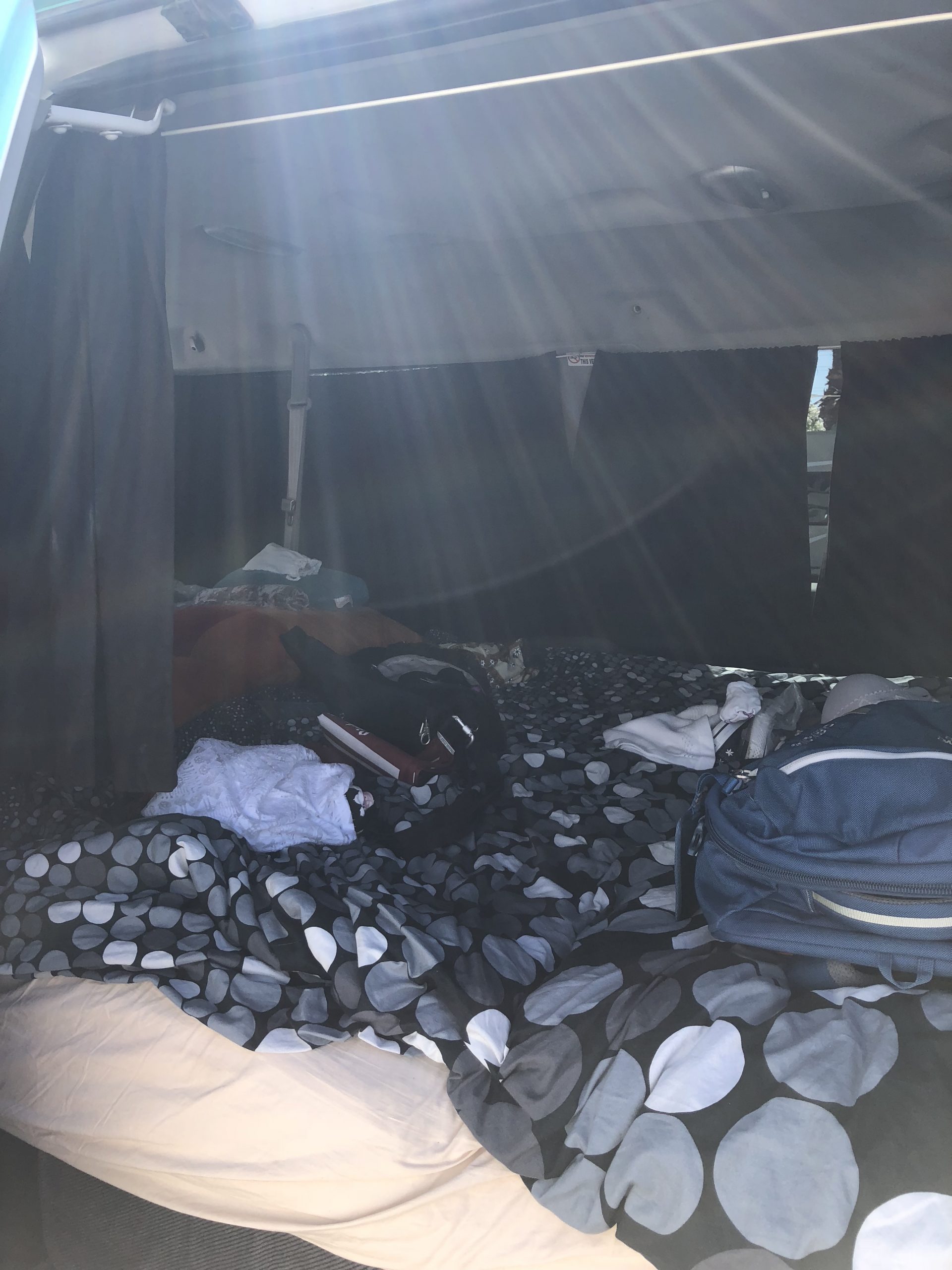 alt="inside of the van with the bed made up"