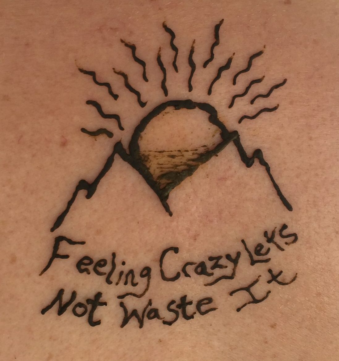 alt="henna tattoo of a mountain & song lyrics"