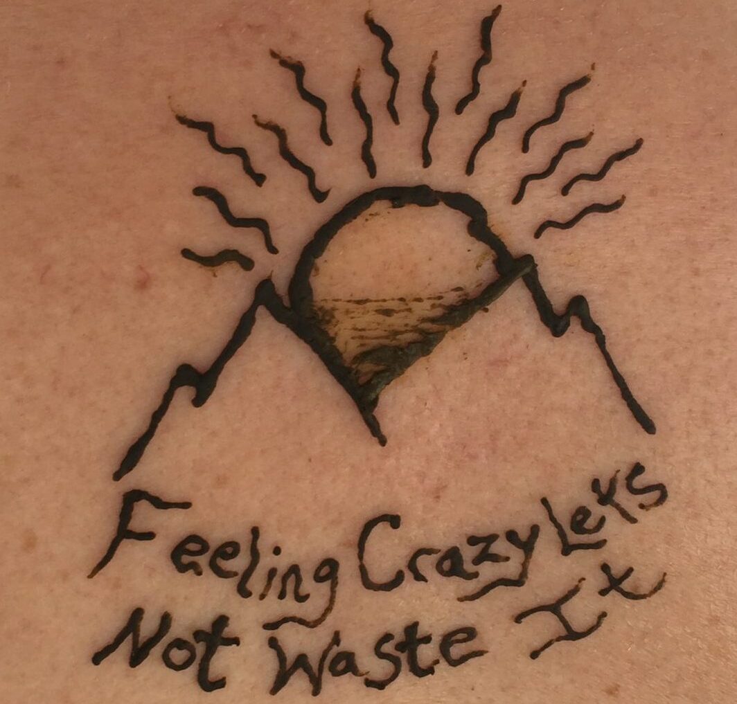 alt="henna tattoo of a mountain & song lyrics"