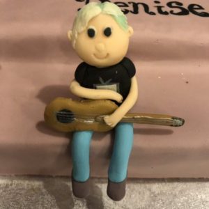 alt="marzipan cake figure of Denise with guitar"