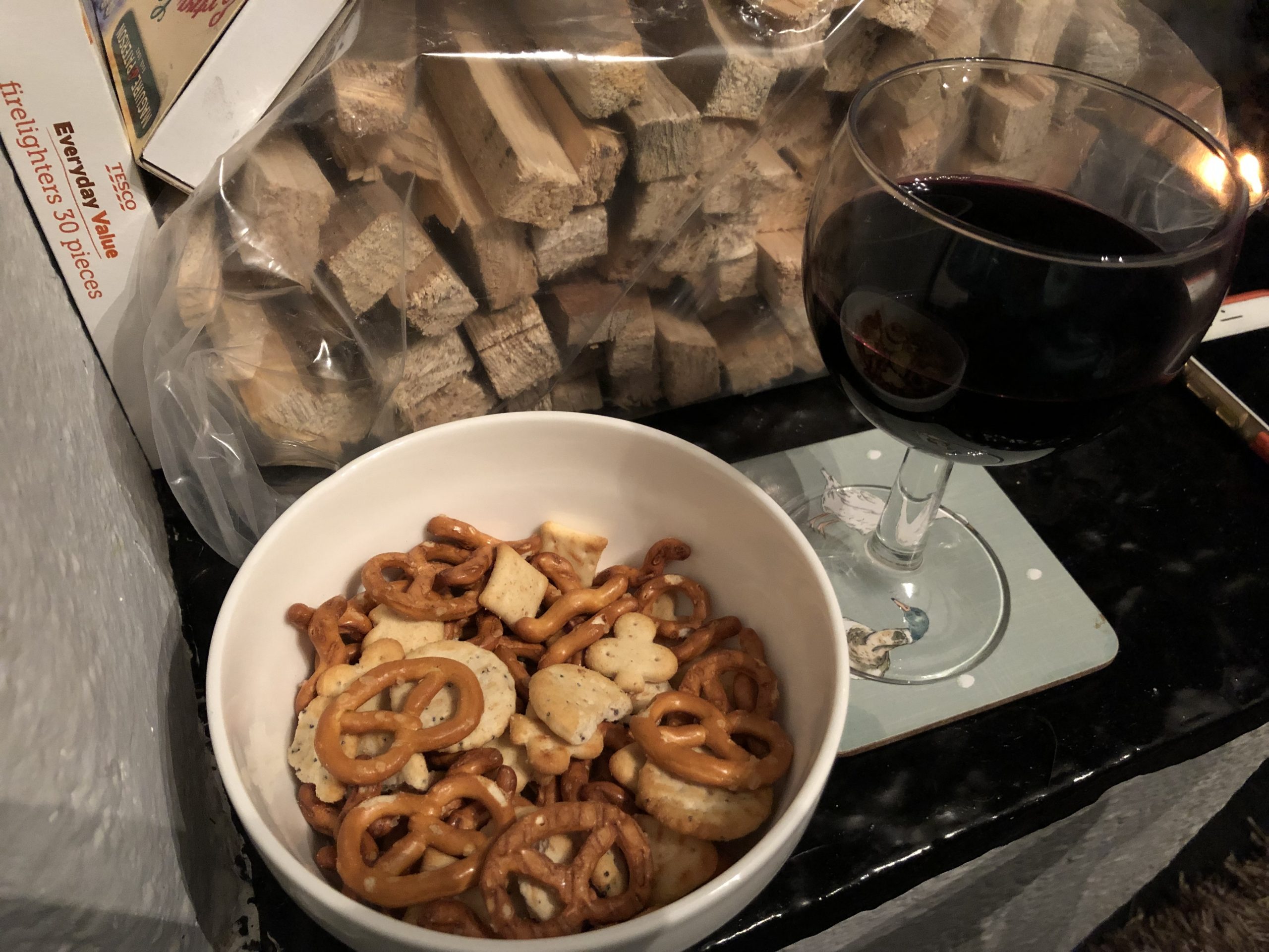 alt="snacks in a bowl with a glass of wine