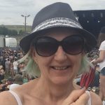 alt="a person wearing a hat & sunglasses"