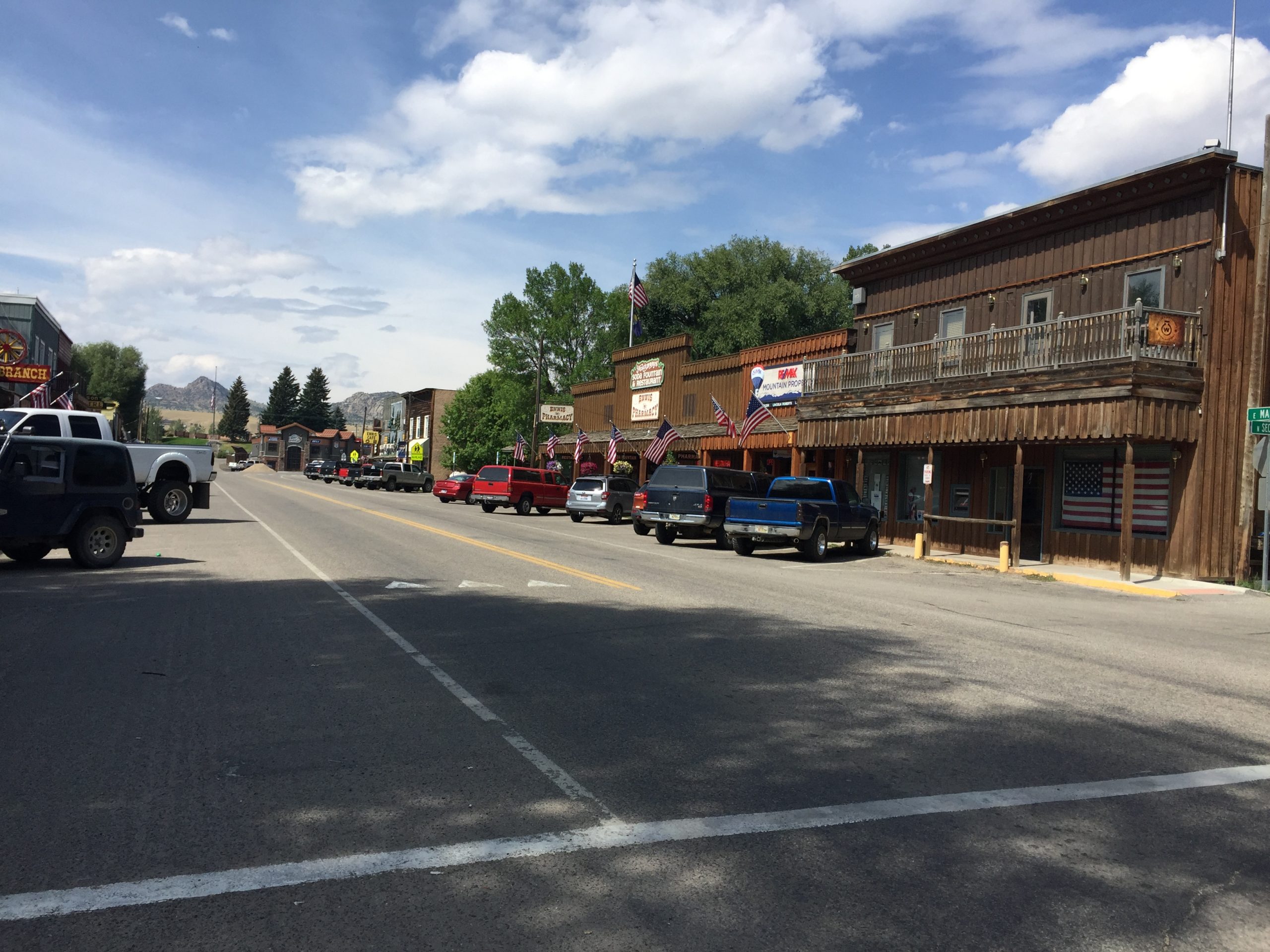 alt="Ennis main street with shops & vehicles"