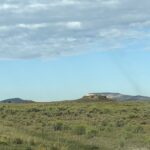alt="grass land with mountain in distance"