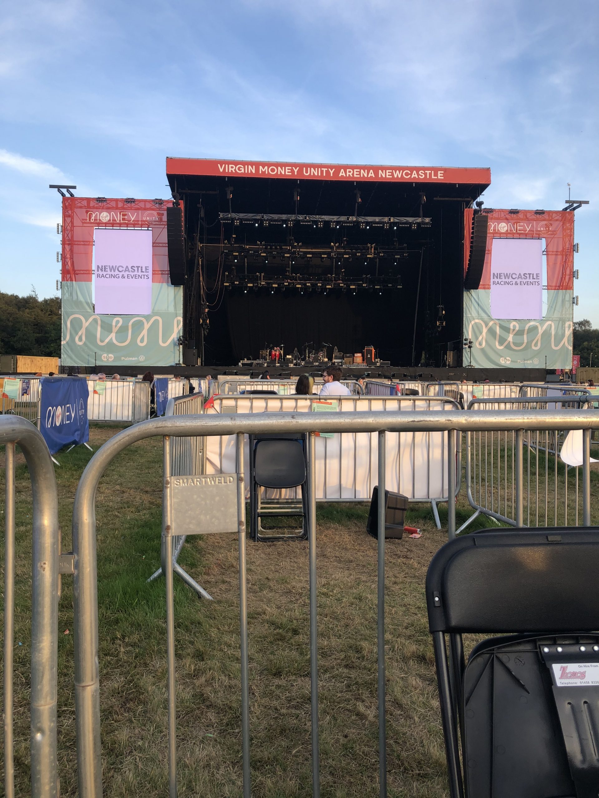 alt="large outdoors music stage & socially distanced pens for the crowd to stand in"