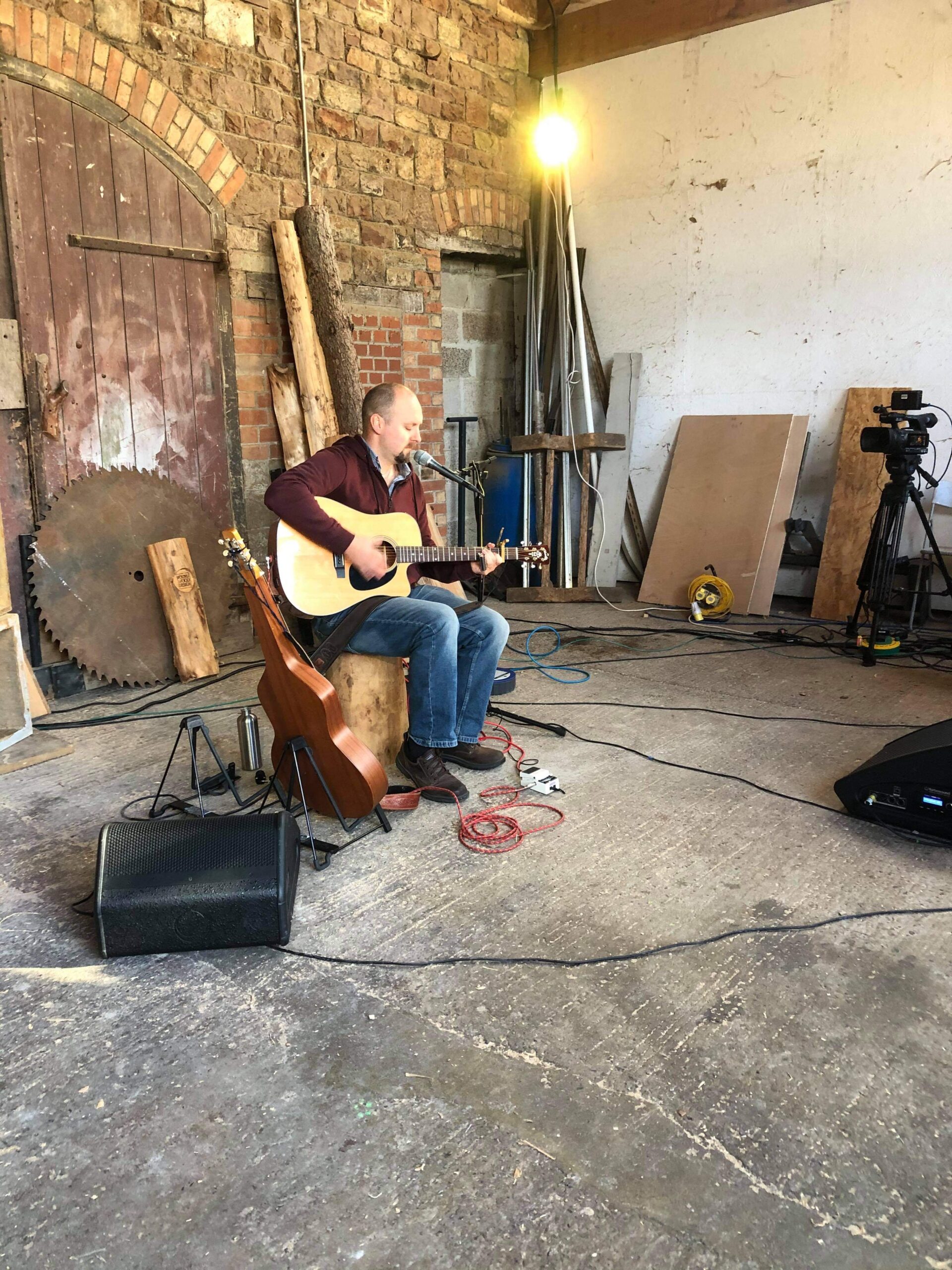 alt="person sat with guitar"