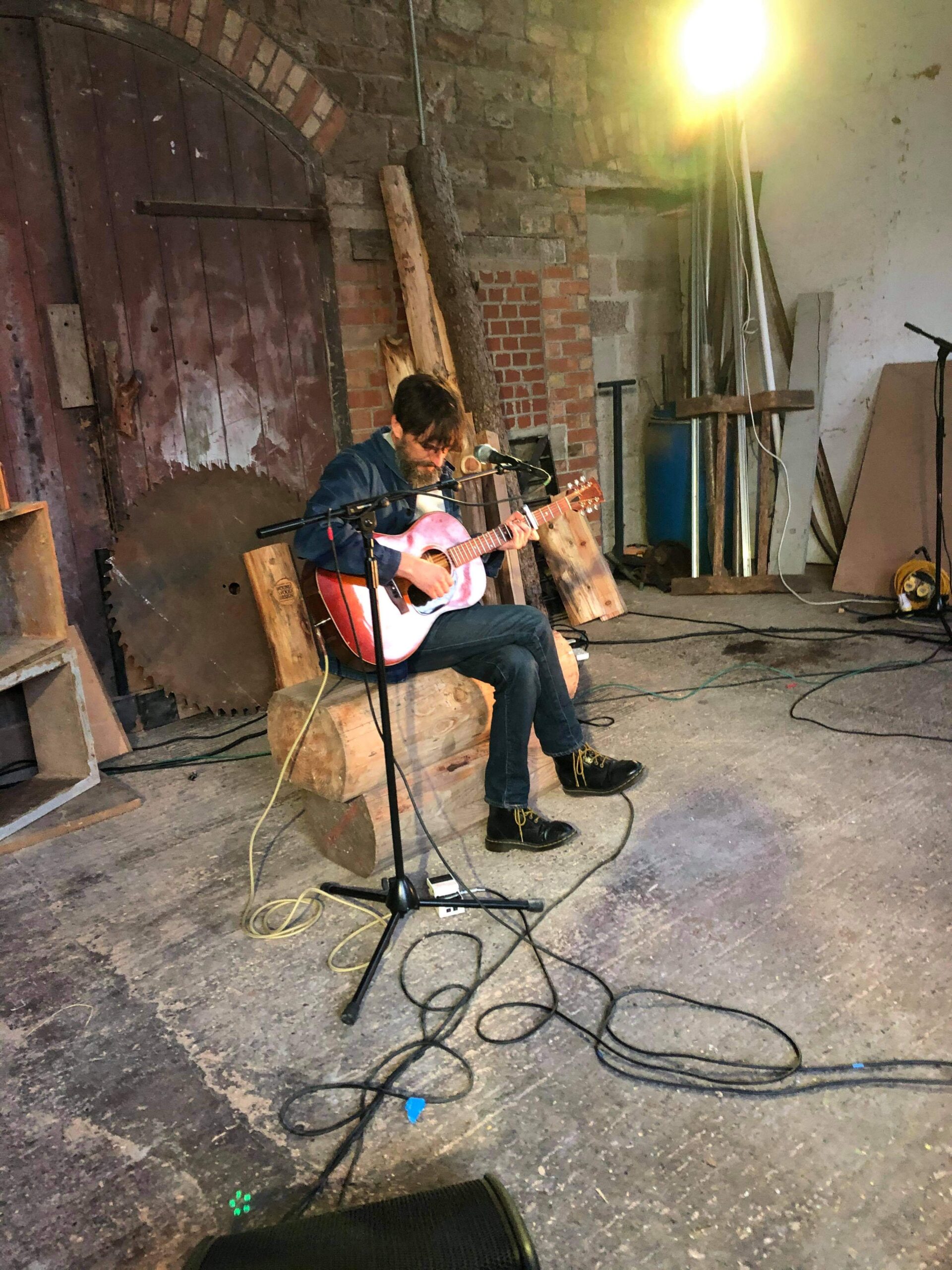 alt="person sat playing guitar"