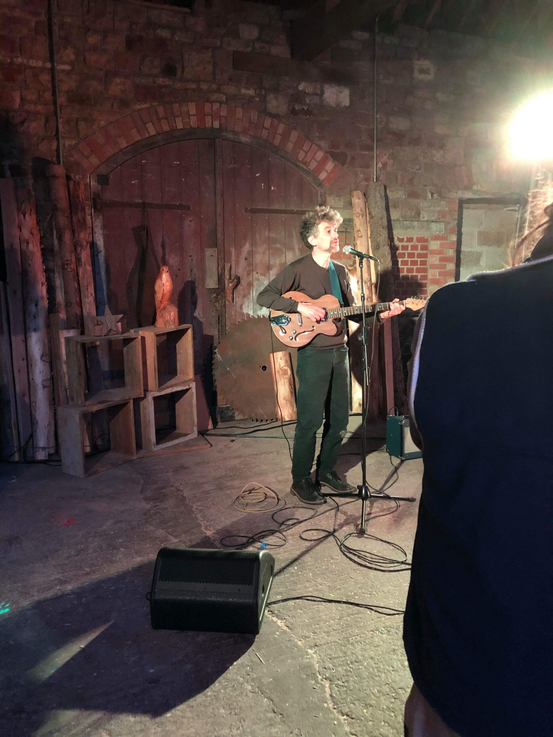 alt="person standing playing guitar"