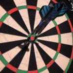 alt="2 darts in outer ring around bullseye"