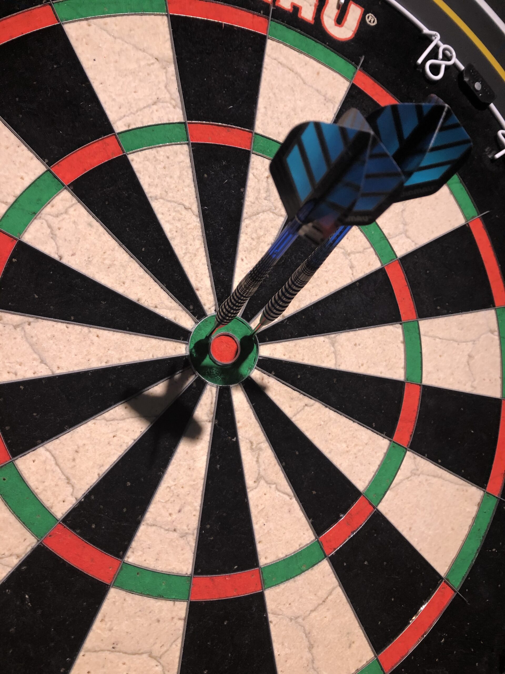 alt="2 darts in outer ring around bullseye"