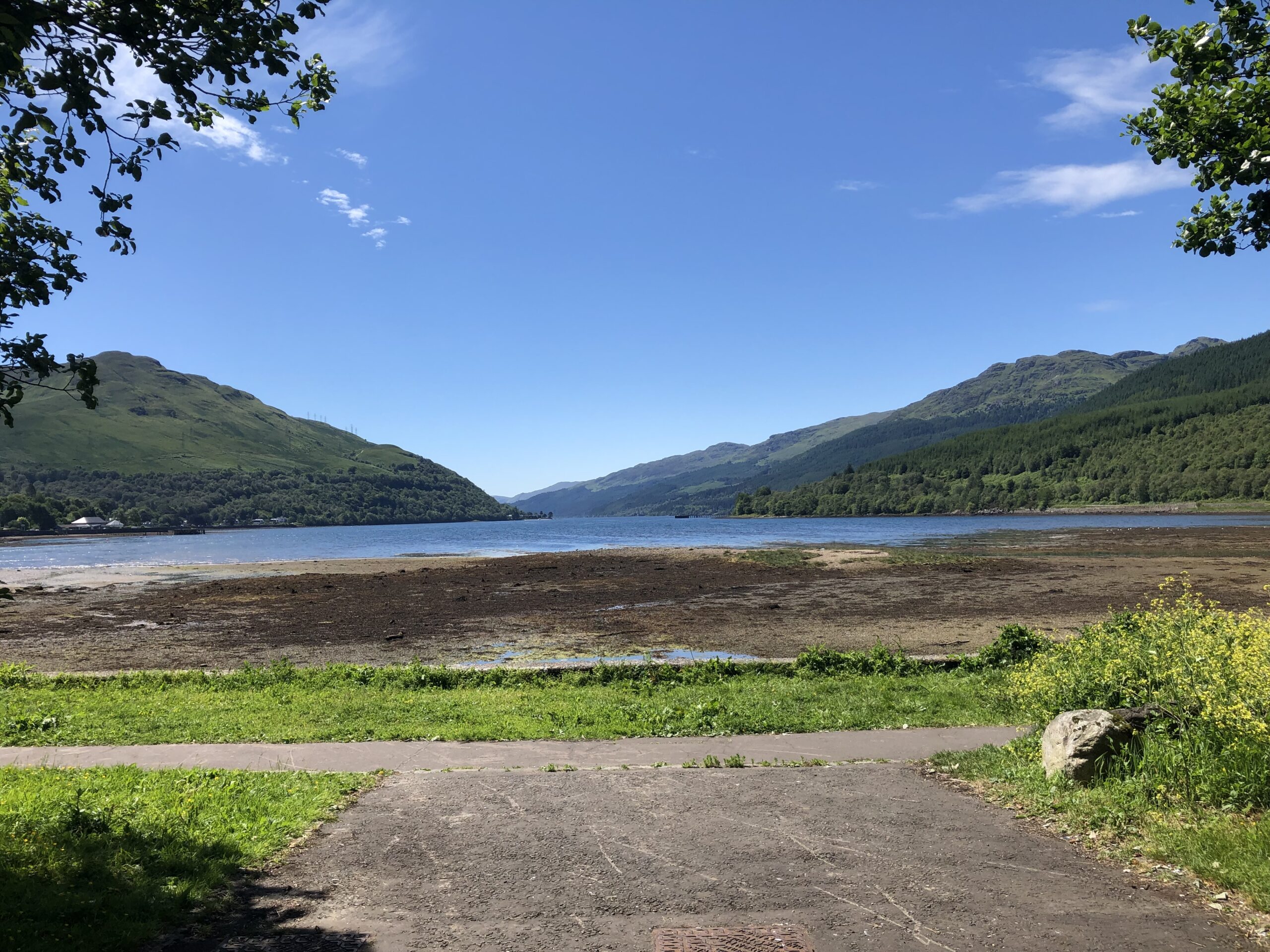 alt="shore with lake & mountains in distance"