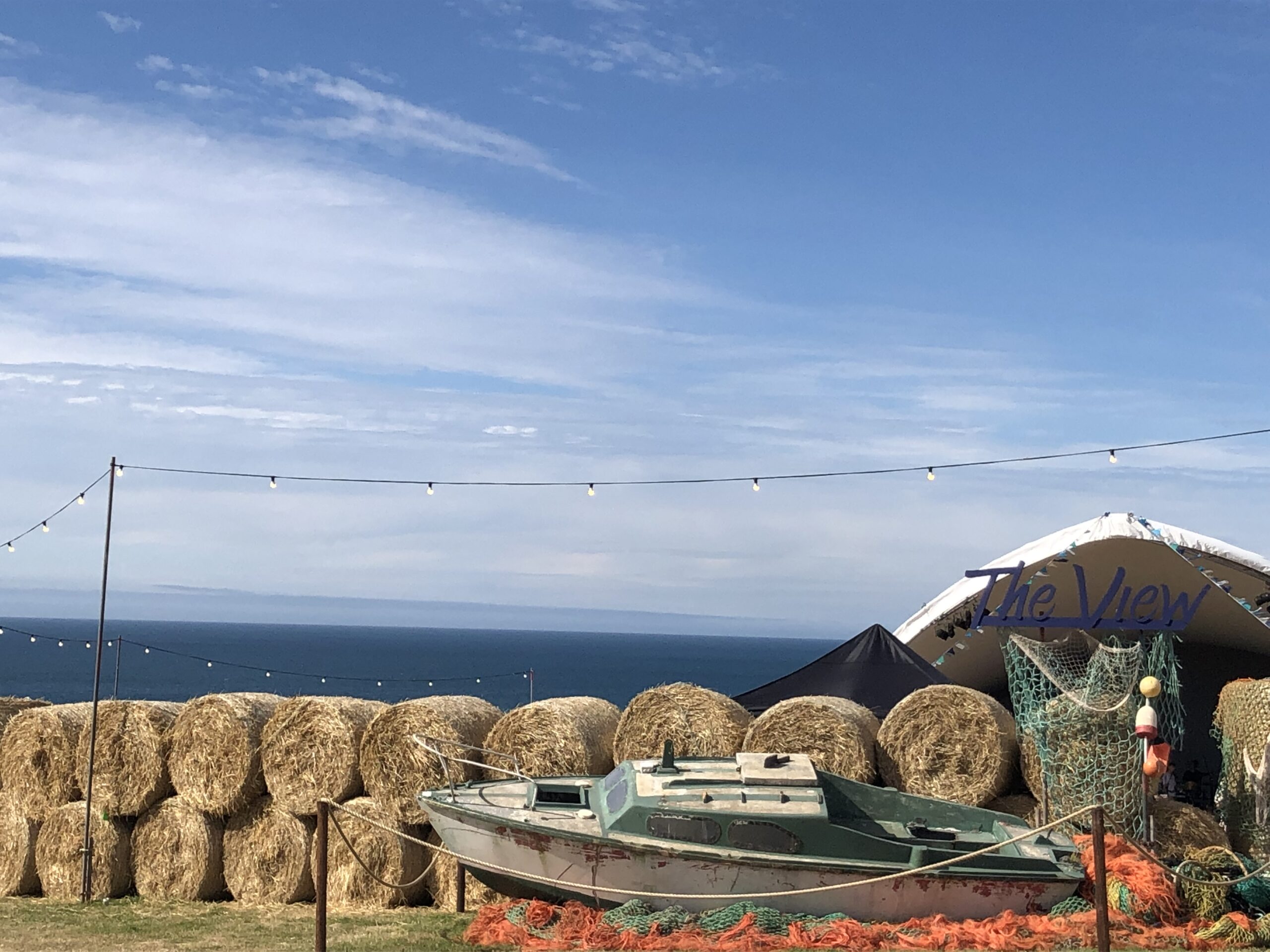 alt="old boat with hay bales behind it"