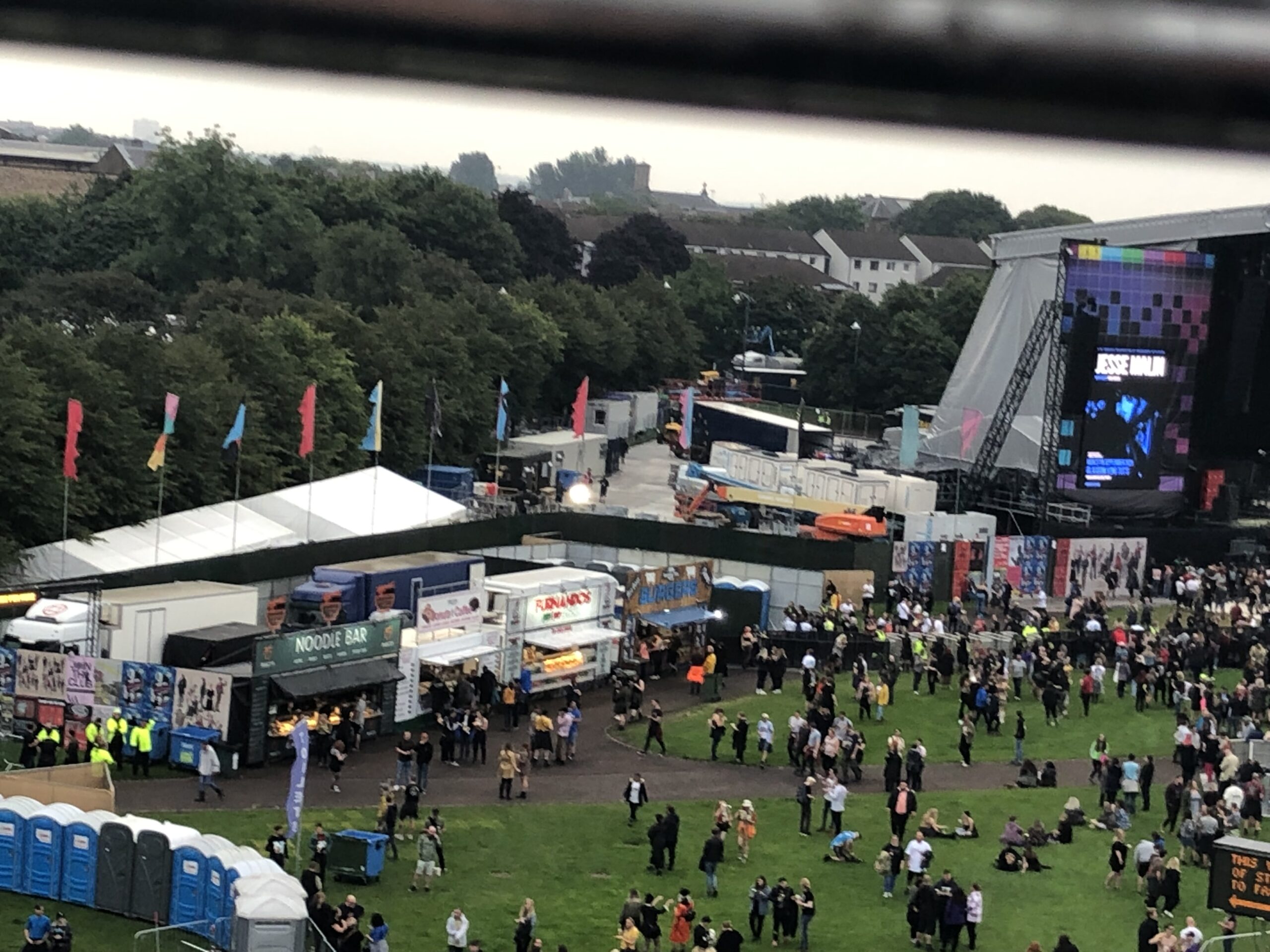 alt="view from top of ferris wheel on crowd & tents"