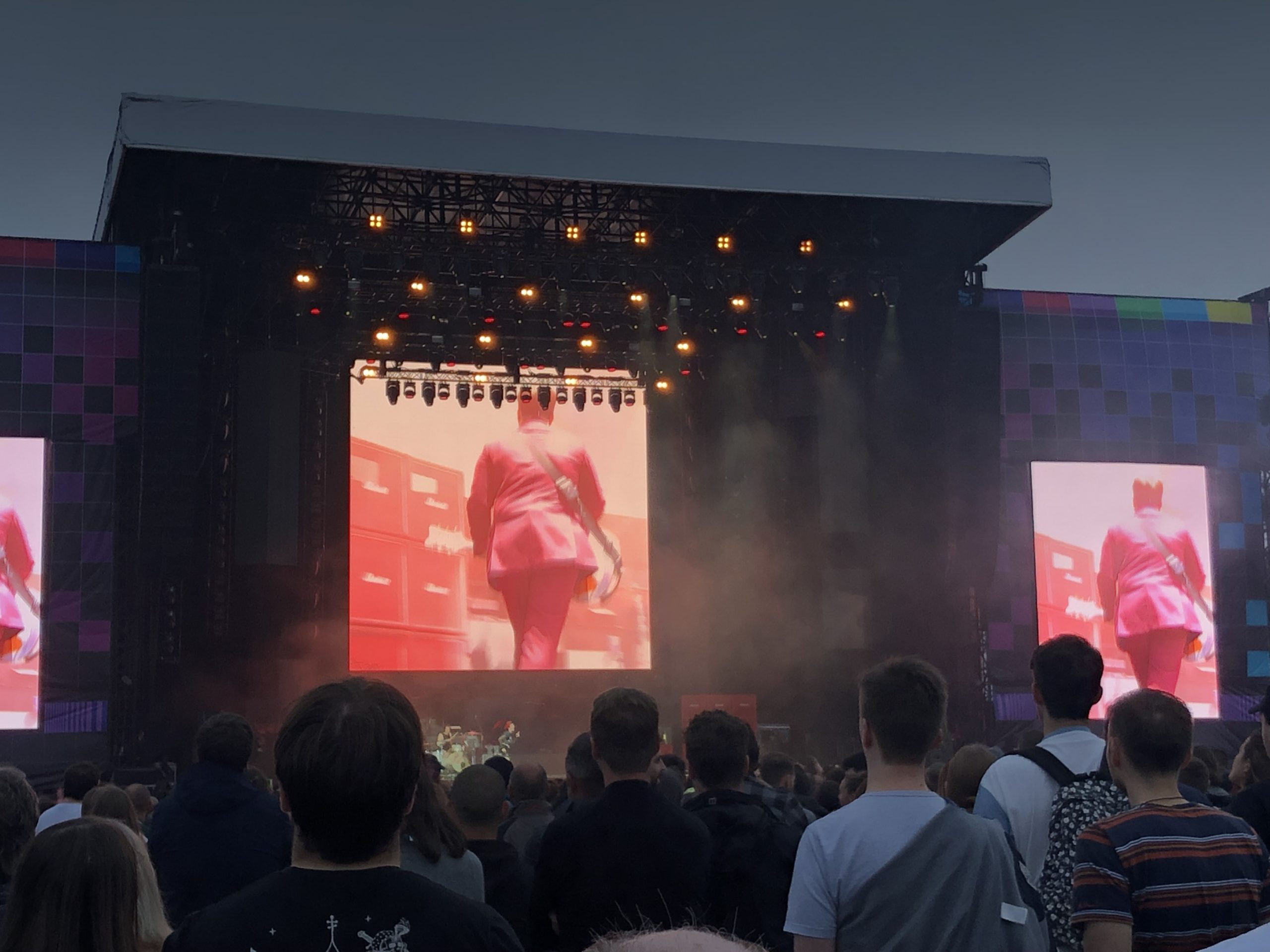 alt="big stage with crowd watching the band"