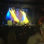 alt="band on stage with lights"