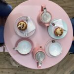 alt="arial view of table with teapots & cakes"