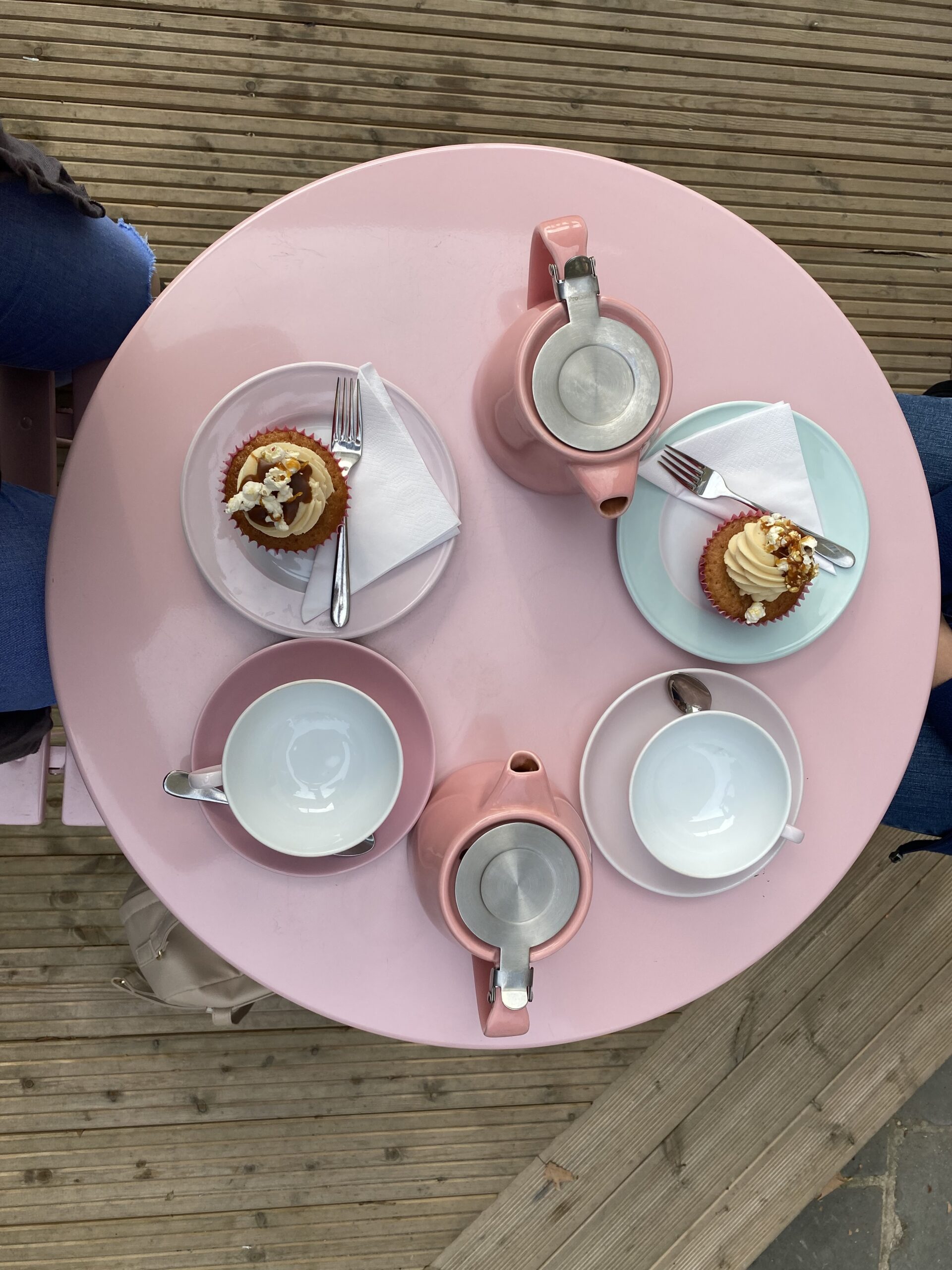 alt="arial view of table with teapots & cakes"