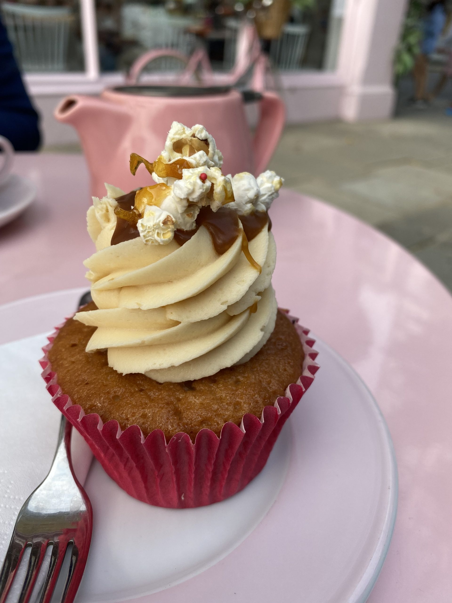 alt="a cupcake with whipped swirl of cream & popcorn decoration"