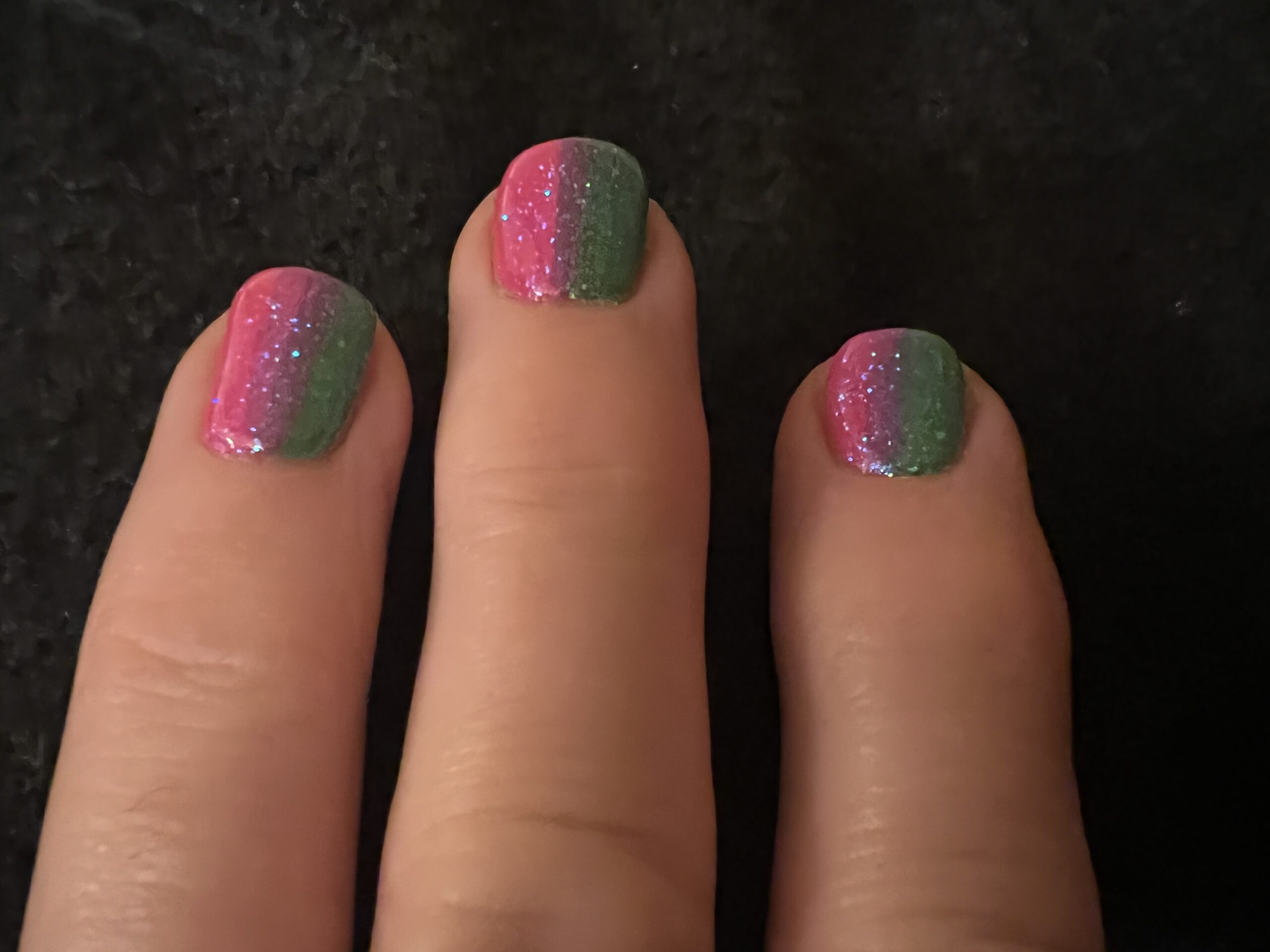alt="fingers with two nail polish colours"