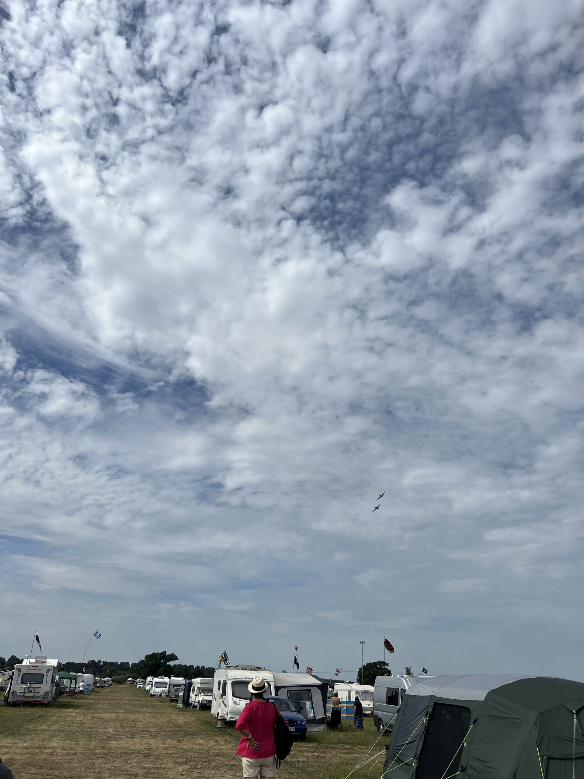 alt="sky with clouds above camp site & historic flight"