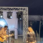 alt="two musicians in front of stage"