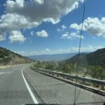 alt="road with mountains & clouds"