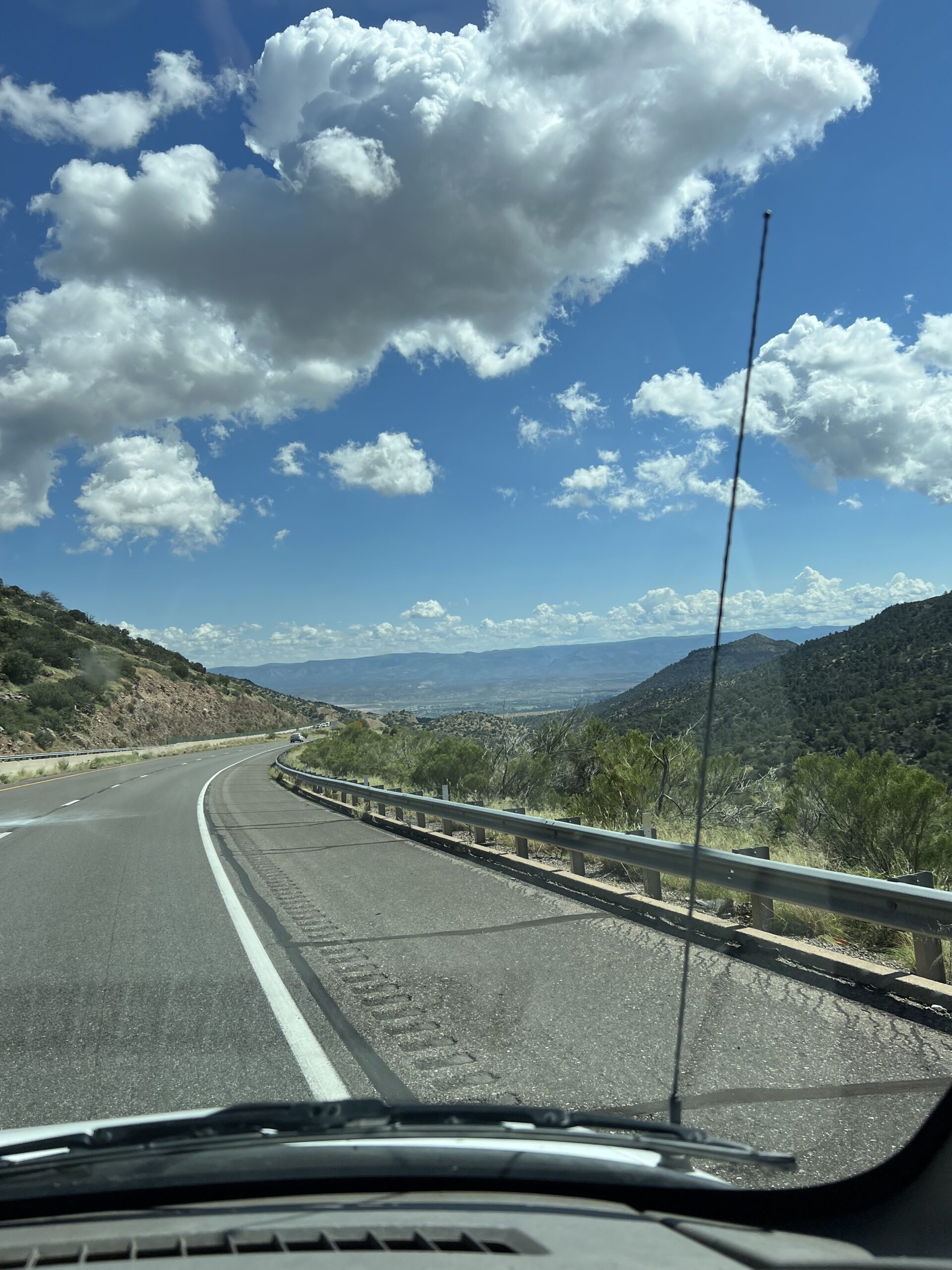 alt="road with mountains & clouds"