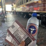 alt=Hand holding tickets & water bottle"