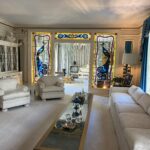 alt="room of pale coloured furniture with stained glass panels"