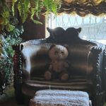 alt="large chair with old teddy bear sat on it"