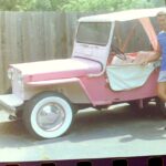 alt="jeep with candy stripe seat & person stood next to it"