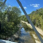 alt="river with stoney shore & trees"