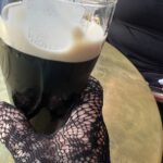 alt="pint of guiness in a gloved hand"