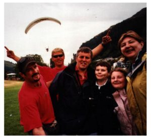 alt="group of people with paragider in background"