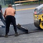 alt="man putting down tarmac"