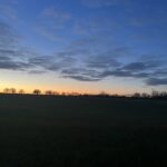 alt="cloud with sun glowing on horizon"