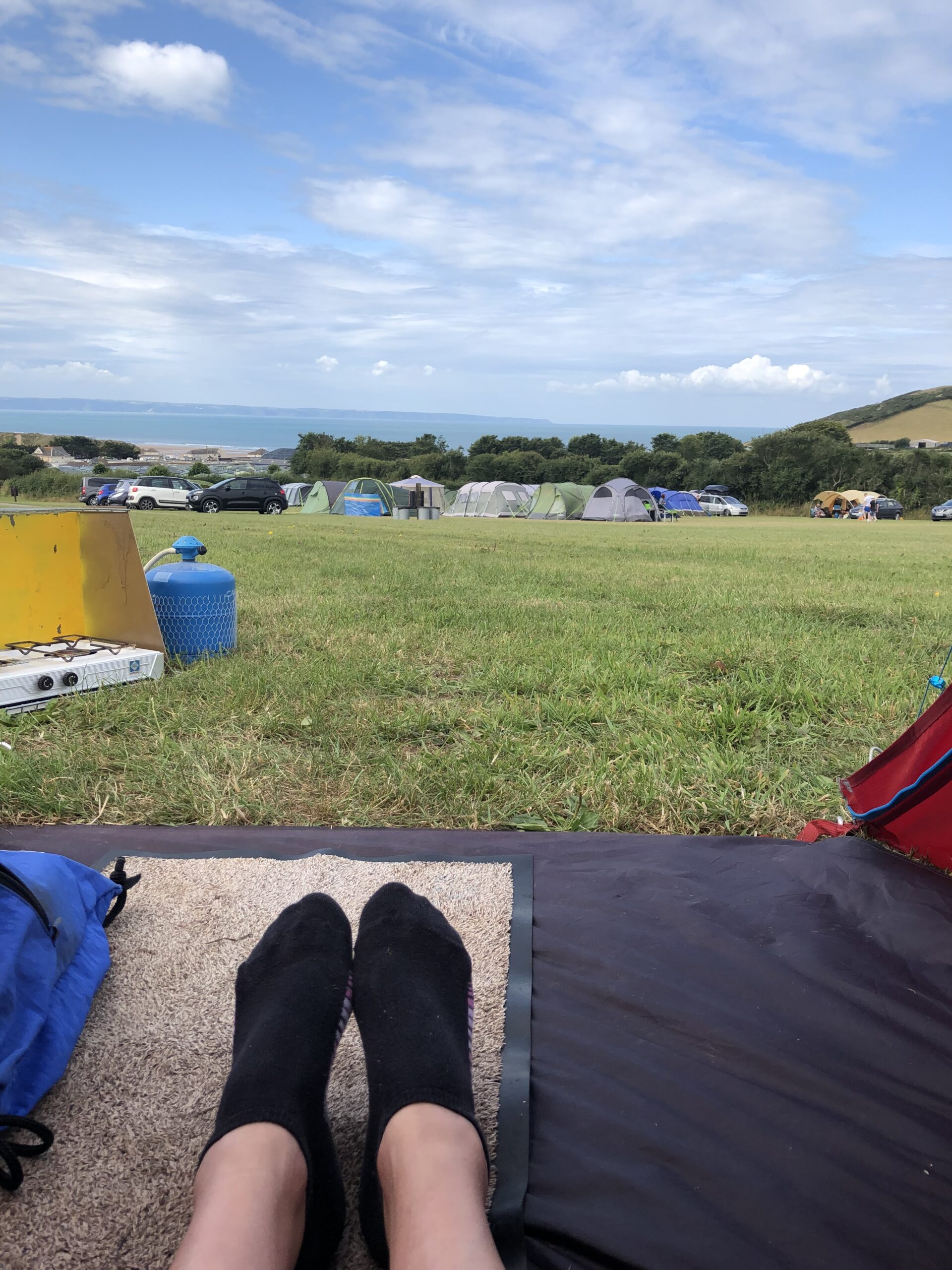 alt="pair of feet in entrance to small tent"