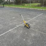 alt="measuring wheel on tarmac"
