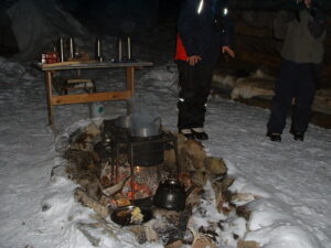 alt="people standing around fire in igloo"