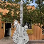 alt="large guitar made of metal with unique patterns"