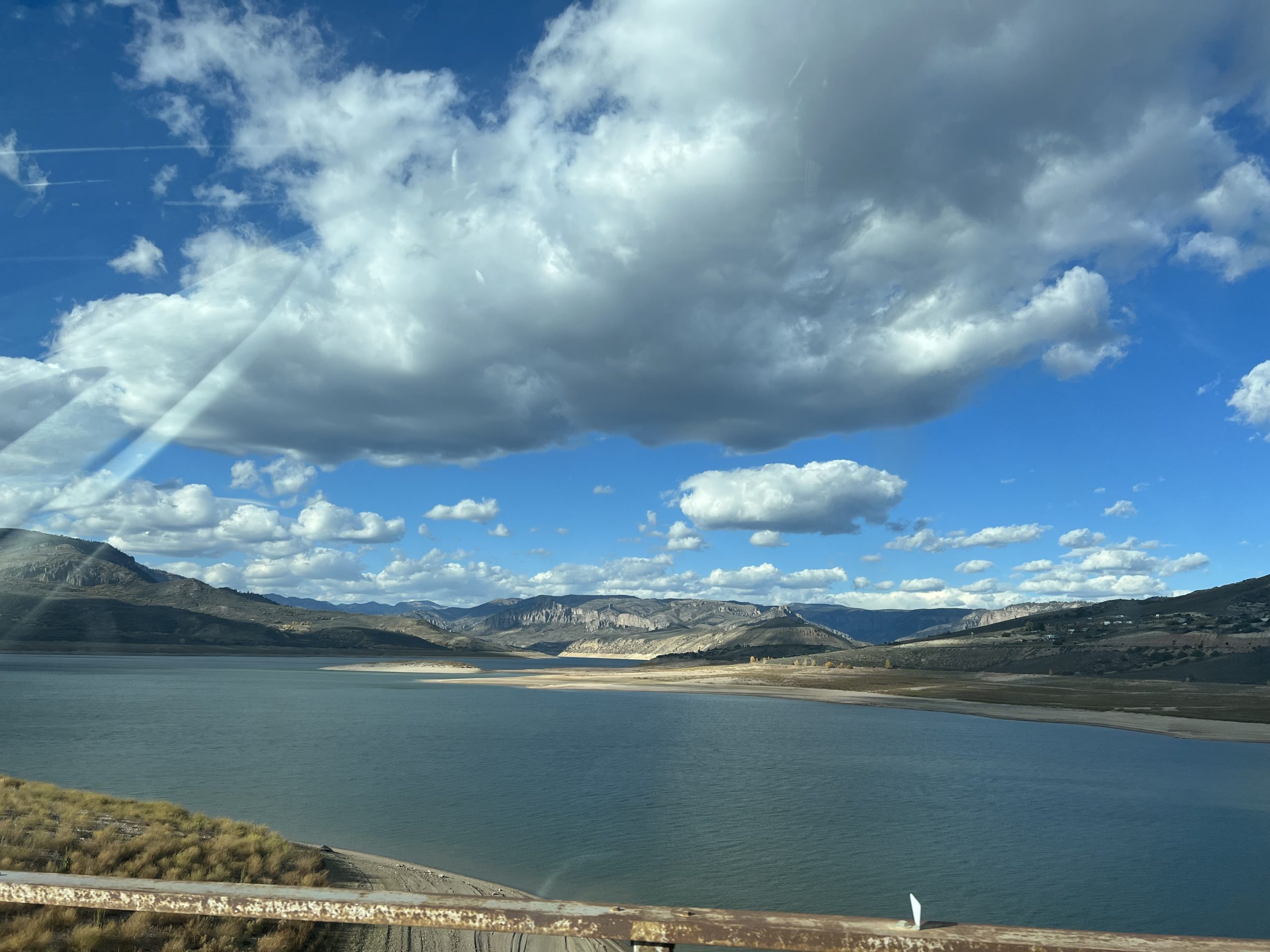 alt="open water with mountains & clouds"