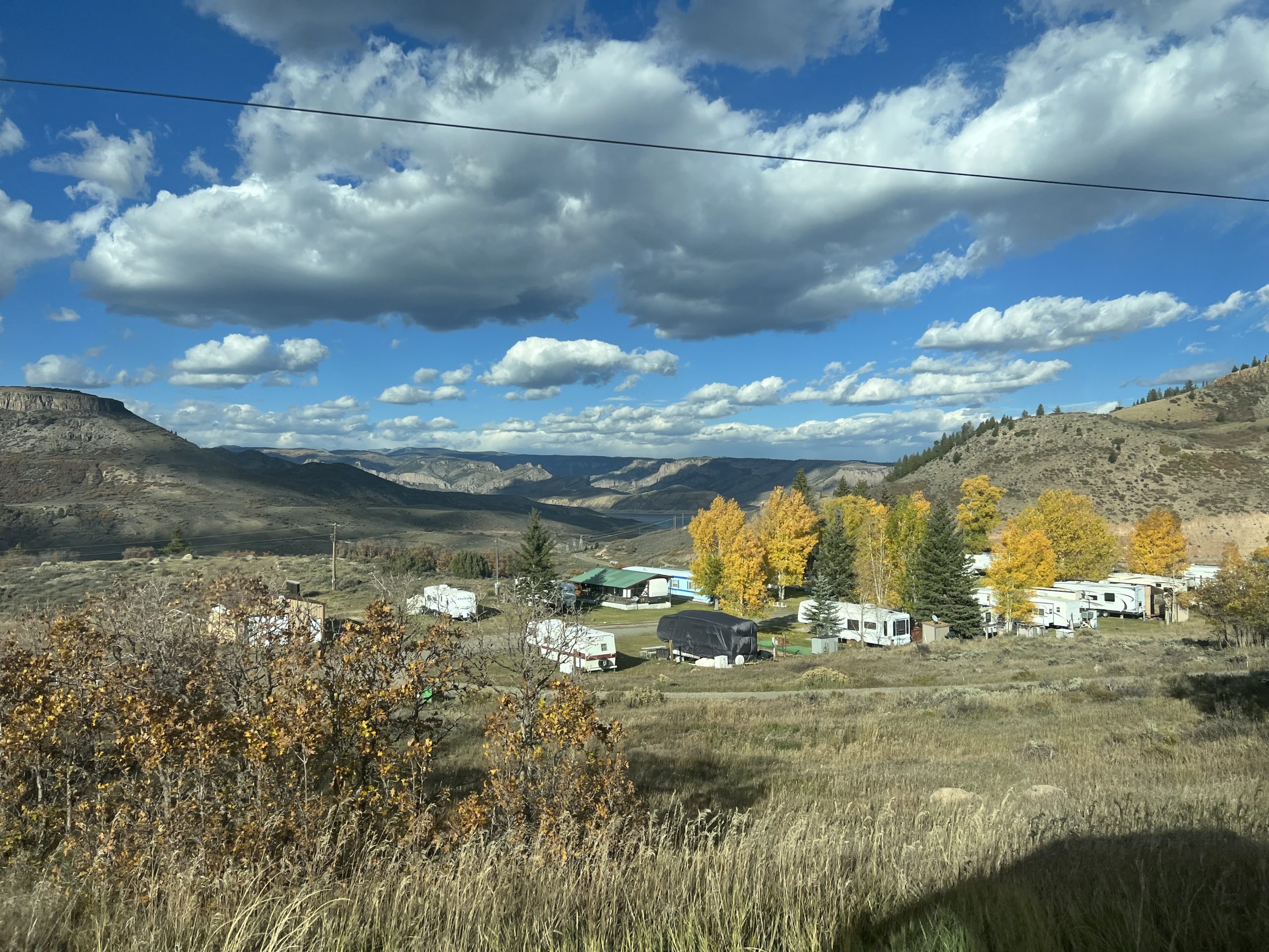 alt="scrubland with trees & clouds"