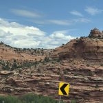 alt="hills on side of road with few trees"