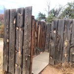 alt="unusual wooden stake toilet enclosure"