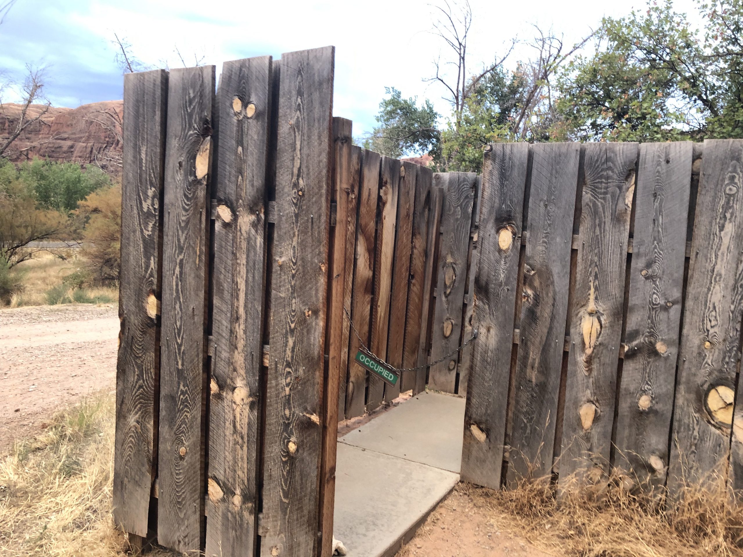 alt="unusual wooden stake toilet enclosure"