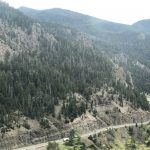 alt="road with arid landscape & trees"